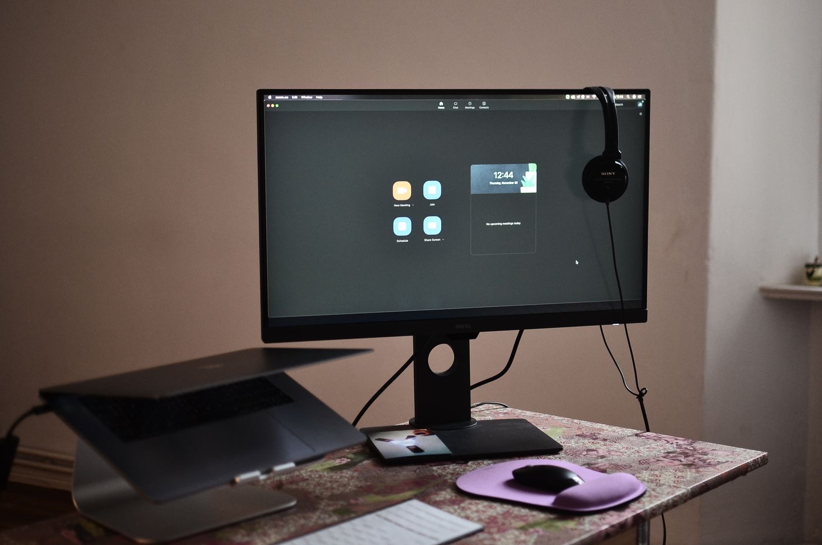 Laptop with a video call and documents ready for signing on a desk