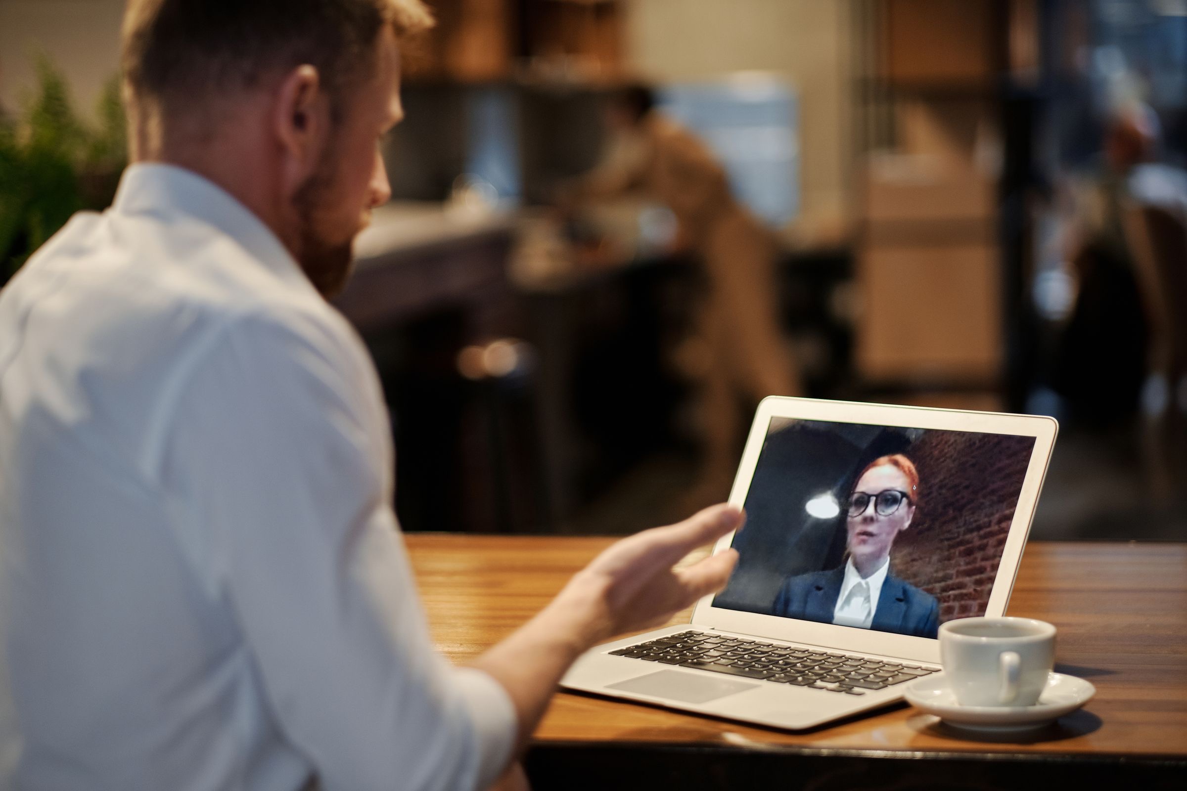Founder at a laptop on a video call, documents on the desk