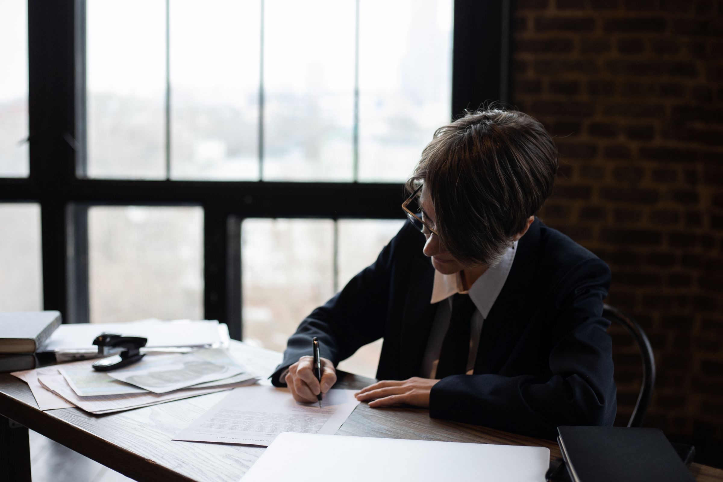 A desk in a Rome office with a laptop and a folder of company formation documents