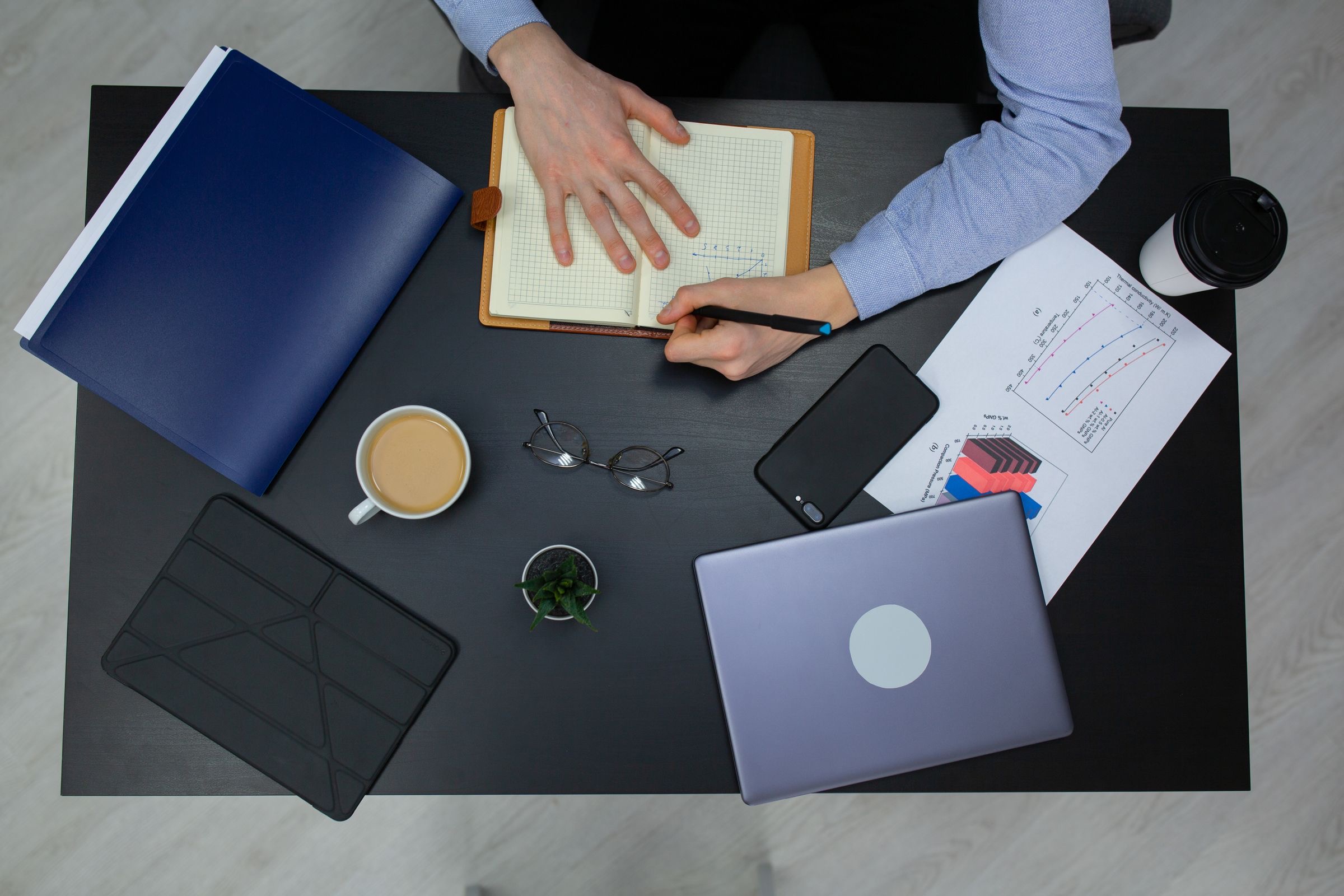 A passport and a folder of papers on a desk