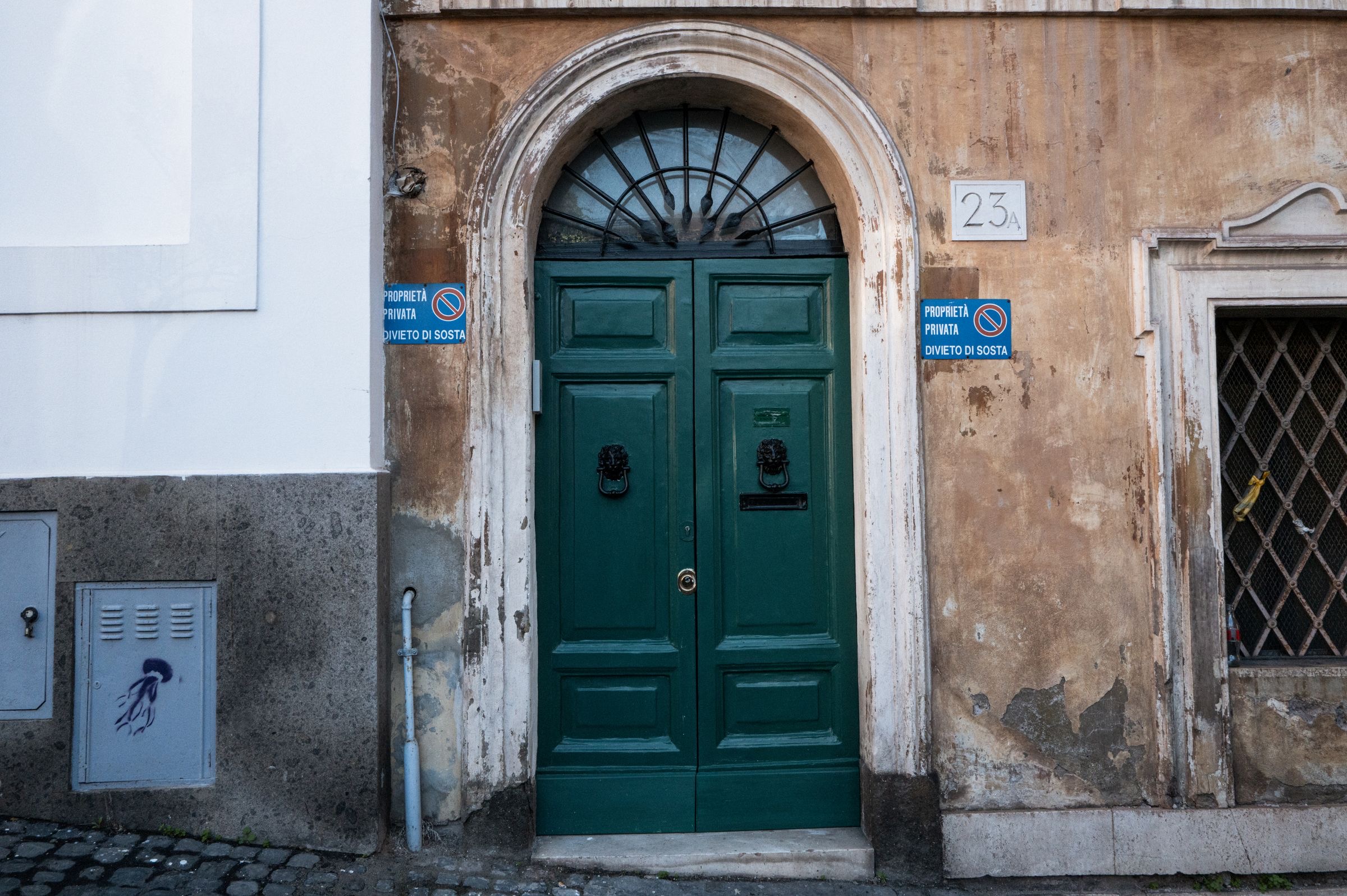 Entrance of a Rome building with a blurred brass plate beside the door