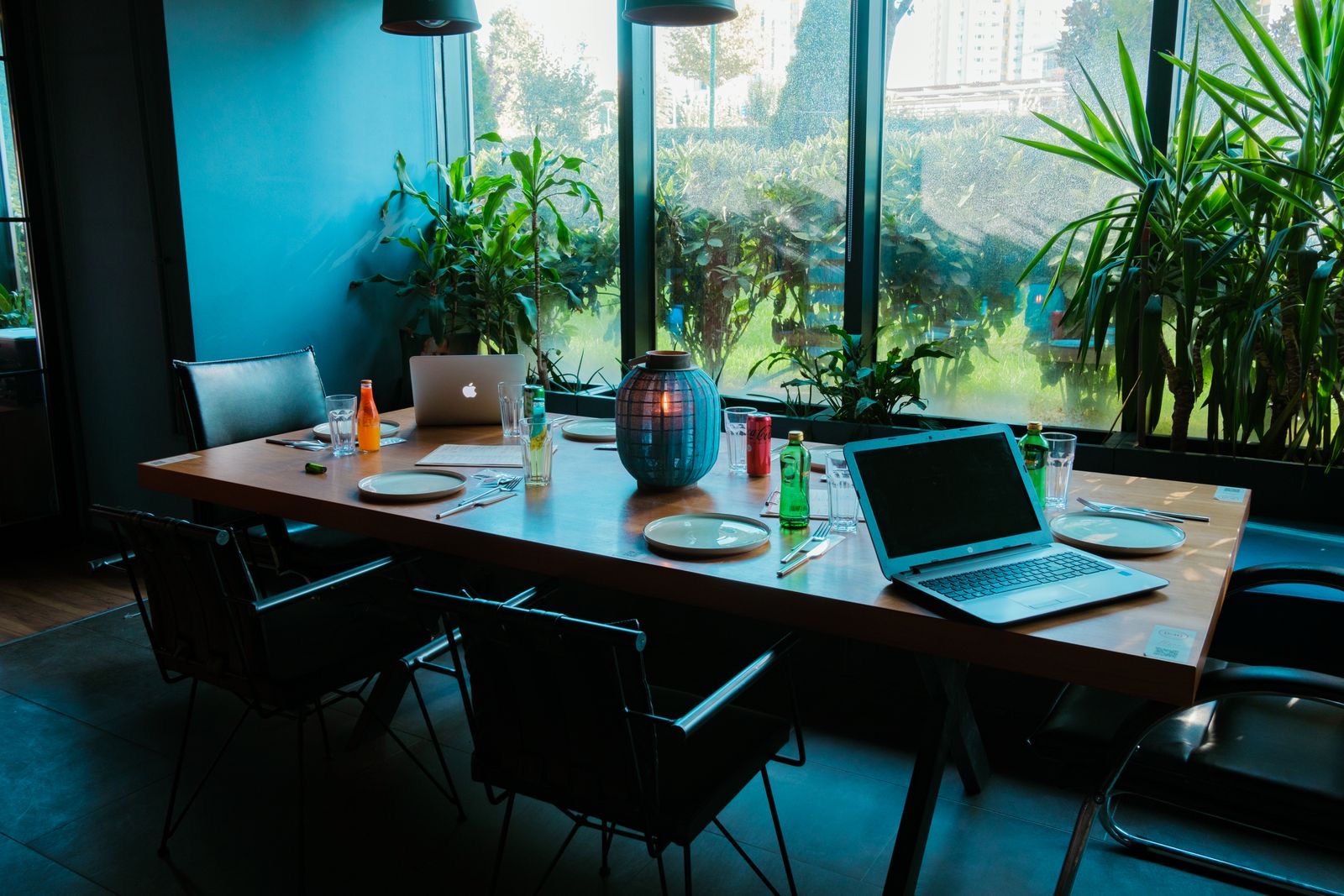 Office desk by a window with a laptop, envelopes and document folders