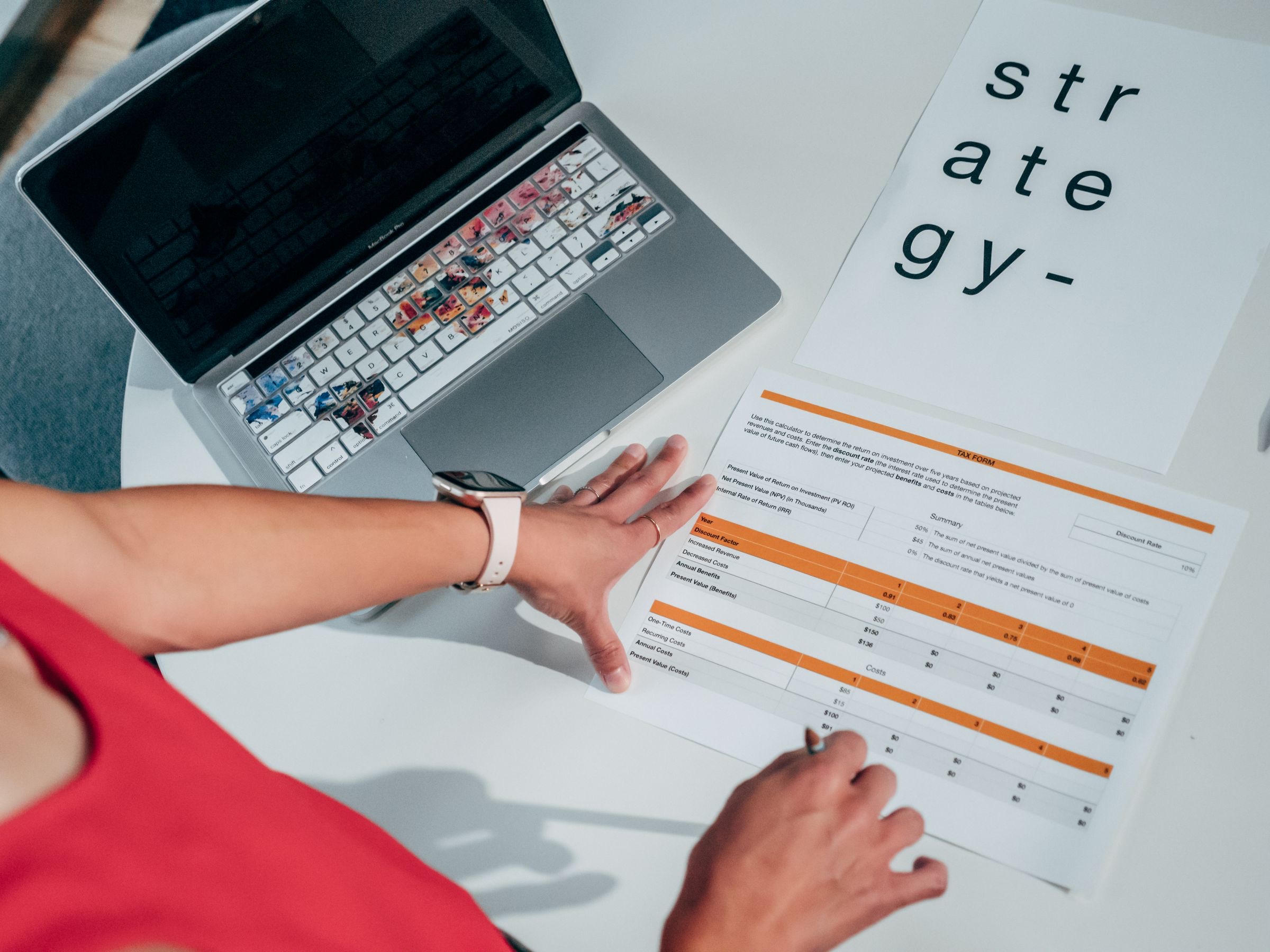 A person at a desk with a laptop and a notebook, preparing papers for a company registration.