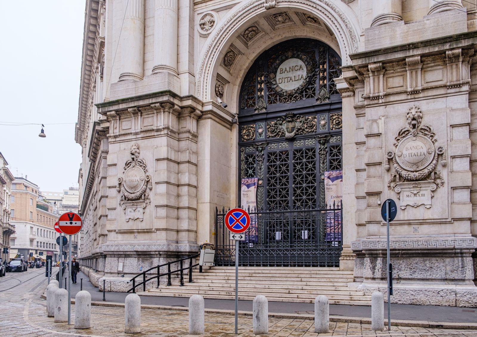 Street entrance of a Milan building with brass name plates beside the door