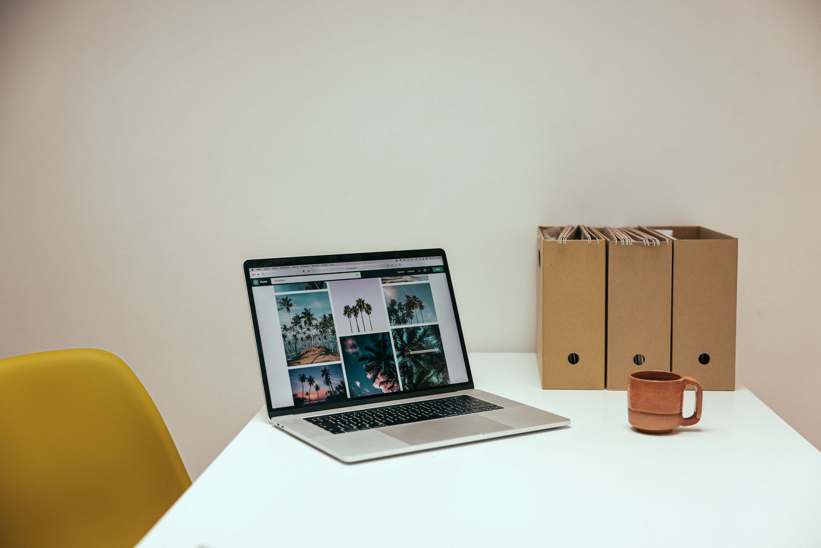 A laptop and box files on a desk