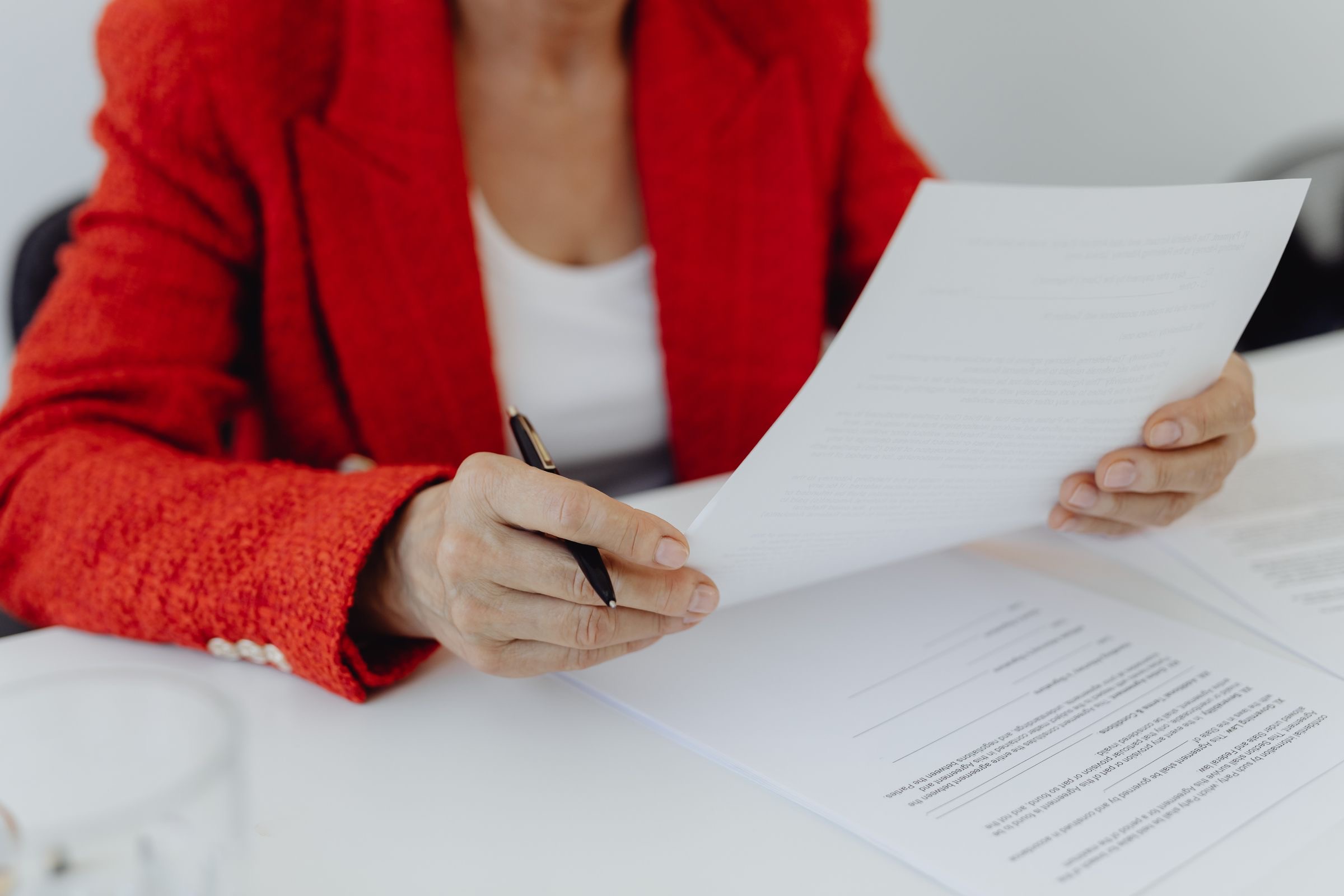 A pen resting on a deed of incorporation at a notary's desk