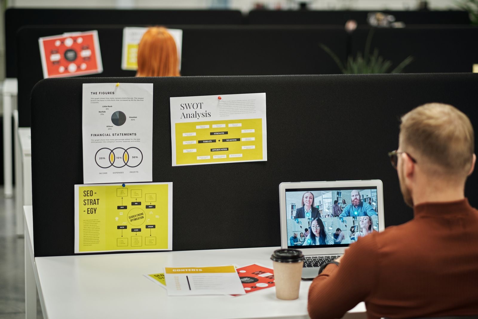 A laptop video call with signing papers on a desk beside it