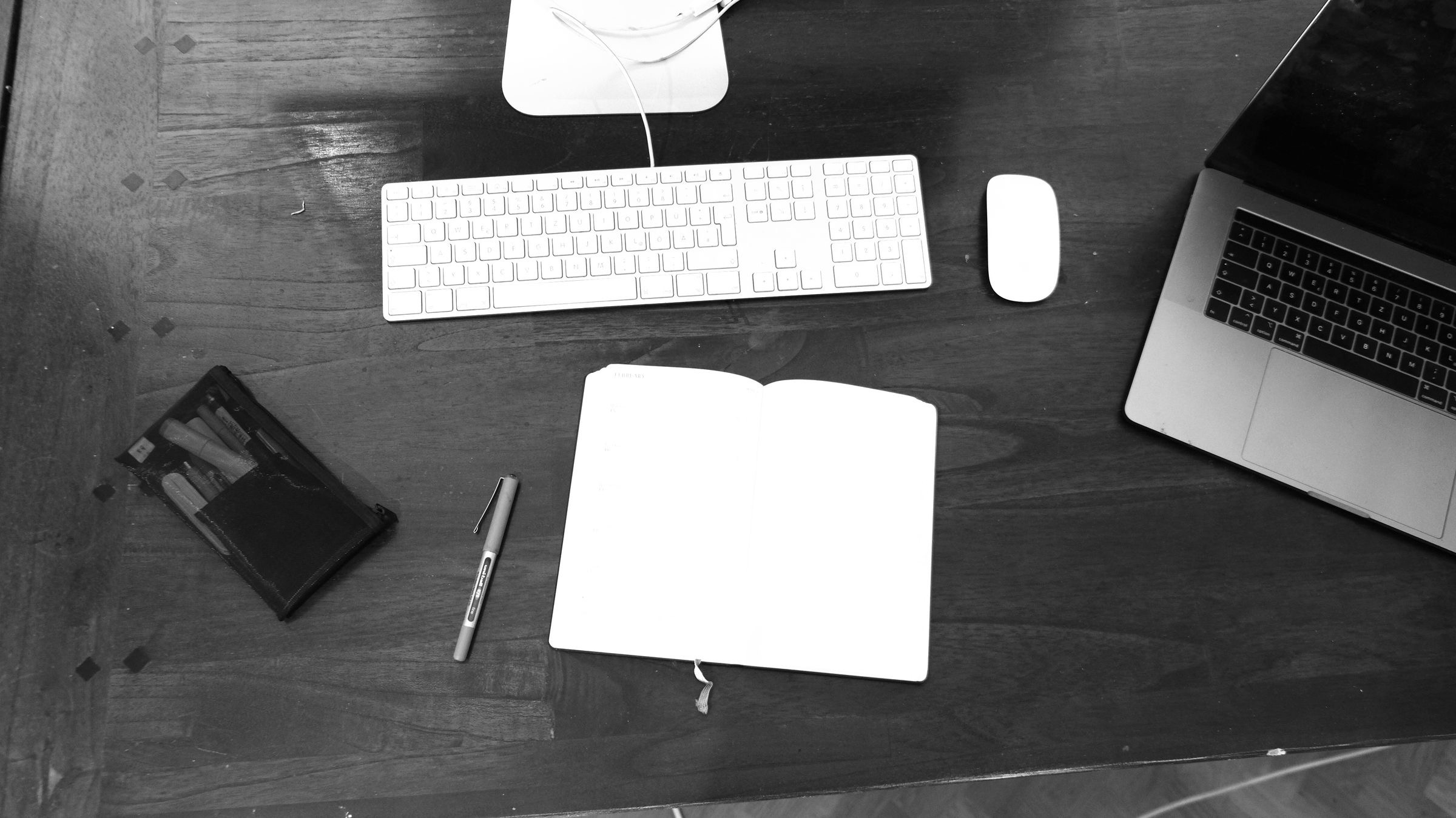 A passport and a folder of documents on a desk beside a stamp pad